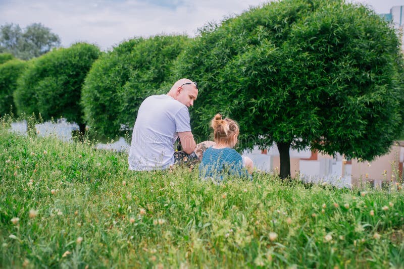 Baby und ihr Vater, die im Park sitzen R?ckseitige Ansicht lizenzfreie stockbilder Baby und ihr Vater, die im Park sitzen R?ckseitige Ansicht lizenzfreie stockbilder