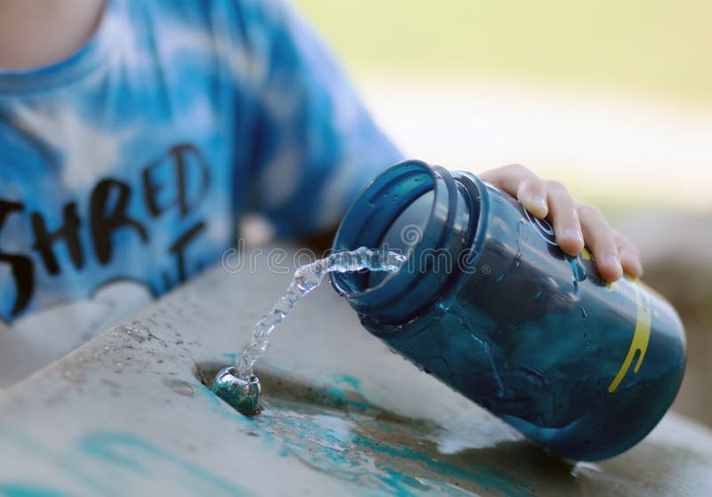 Baby with water bottle near the cooler stock images Baby with water bottle near the cooler stock images