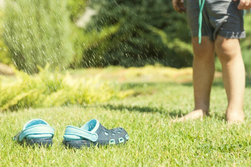 Babybenen En Kinderen` S Blauwe Pantoffels Op Het Groene Gras in De ...