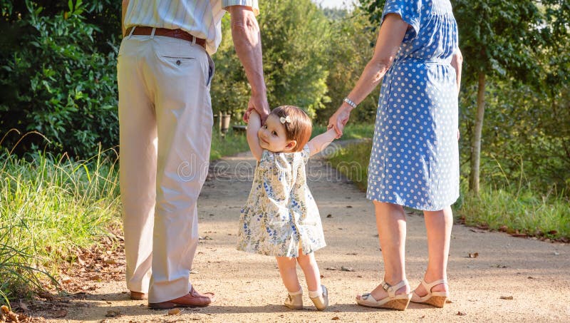 Babyenkelin, die draußen mit ihren Großeltern geht stockbilder Babyenkelin, die draußen mit ihren Großeltern geht stockbilder