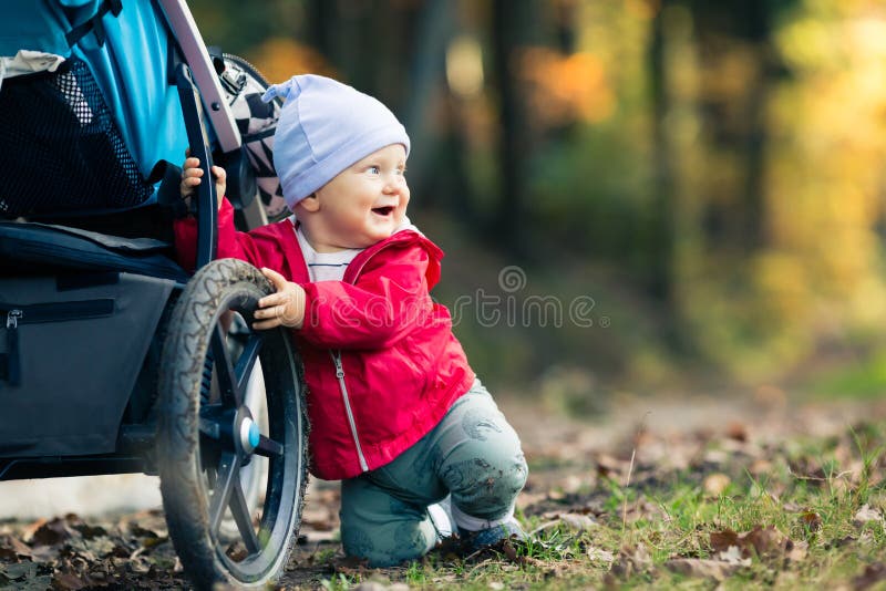 Babyjongen het spelen in de herfstbos met wandelwagen, in openlucht pret stock foto's Babyjongen het spelen in de herfstbos met wandelwagen, in openlucht pret stock foto's