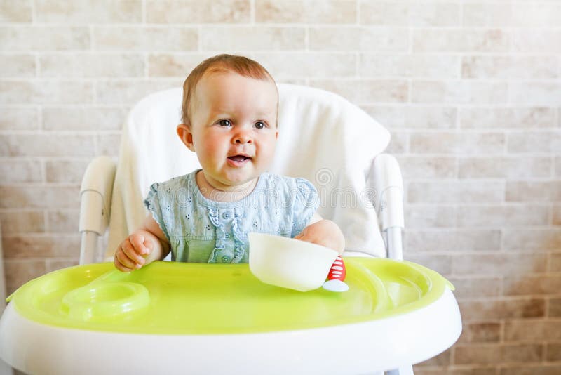 Babykind die met lepel in zonnige keuken eten Portret van gelukkig jong geitje als hoge voorzitter De ruimte van het exemplaar royalty-vrije stock fotografie Babykind die met lepel in zonnige keuken eten Portret van gelukkig jong geitje als hoge voorzitter De ruimte van het exemplaar royalty-vrije stock fotografie