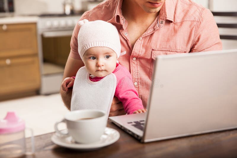 Babymeisje die de computer van haar papa bekijken stock foto Babymeisje die de computer van haar papa bekijken stock foto