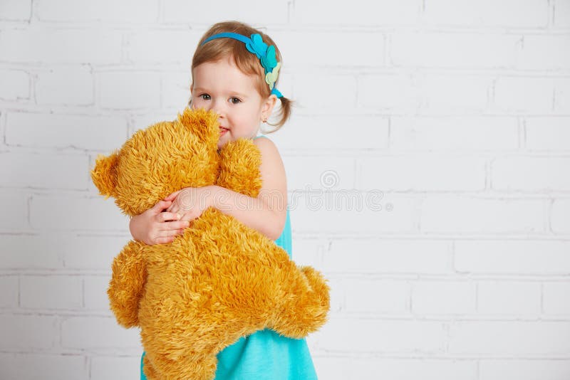 Babymeisje die een gehouden van teddybeer koesteren royalty-vrije stock afbeeldingen Babymeisje die een gehouden van teddybeer koesteren royalty-vrije stock afbeeldingen