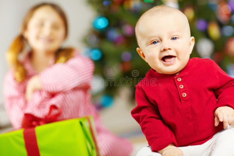 Babyporträtt och gåva från julgranen i hemmet eller glad för överraskning i vardagsrummet. Spädbarn och arkivbild