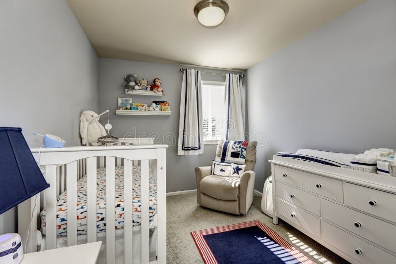 Baby bedroom interior, boy's room. Gray walls and white wooden furniture: chest of drawers, crib. Baby bedroom interior, boy's room. Gray walls and white wooden furniture: chest of drawers, crib.