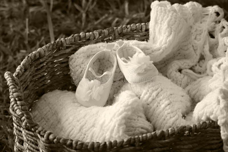 Babyschuhe und Decke in einem Korb stockfotografie Babyschuhe und Decke in einem Korb stockfotografie