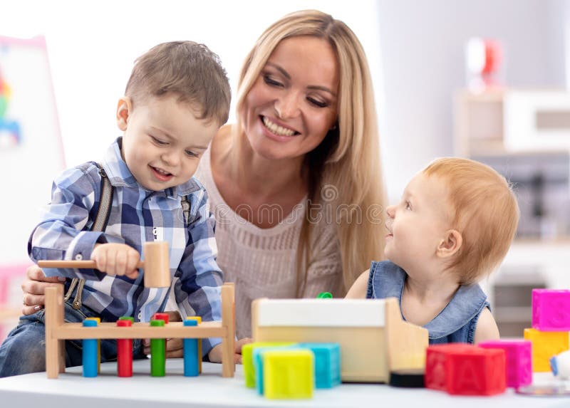 Babysitter and children playing together in nursery or day care centre stock images Babysitter and children playing together in nursery or day care centre stock images