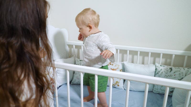 Babystellung in der Krippen- und glücklicher Mutter, die ihn ansehen.