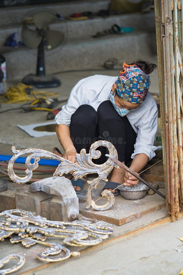 Bac Ninh, Вьетнам - 9-ое сентября 2015: Медные продукты ремесленничества и изящного искусства делаются вручную работником женщины стоковое фото rf Bac Ninh, Вьетнам - 9-ое сентября 2015: Медные продукты ремесленничества и изящного искусства делаются вручную работником женщины стоковое фото rf