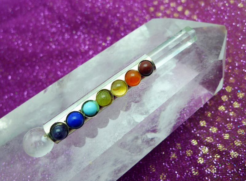 Bacchetta di Chakra sul cristallo di quarzo gigante immagine stock libera da diritti Bacchetta di Chakra sul cristallo di quarzo gigante immagine stock libera da diritti