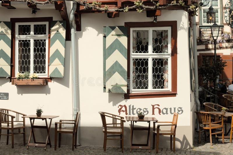 Bacharach, Германия: Половинный timbered дом с таблицами и стульями в саде стоковое фото Bacharach, Германия: Половинный timbered дом с таблицами и стульями в саде стоковое фото