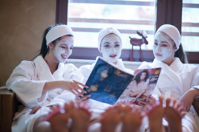 Bachelorette party in spa, girls with face mask reading magazine