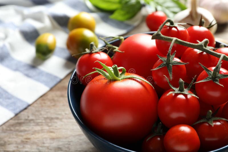 Bacia com os tomates suculentos saborosos na tabela imagens de stock
