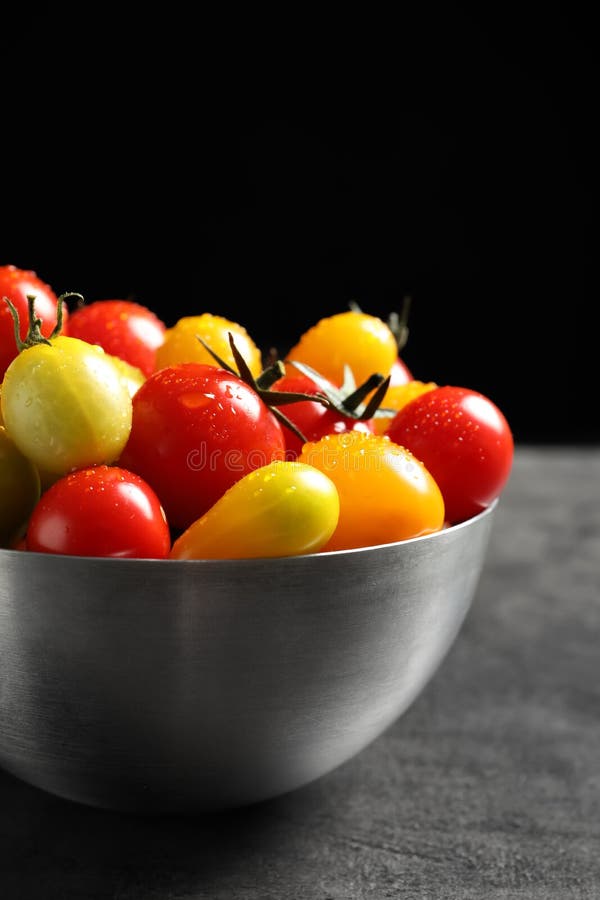 Bacia com os tomates suculentos saborosos na tabela imagens de stock royalty free