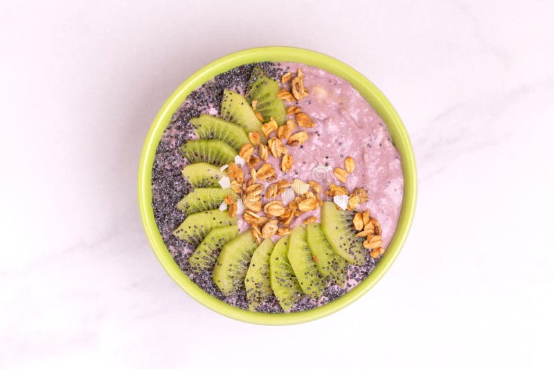 Bacia de Acai com batido do mirtilo, o quivi fresco, o granola e a papoila imagens de stock Bacia de Acai com batido do mirtilo, o quivi fresco, o granola e a papoila imagens de stock
