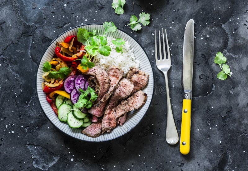 Bacia equilibrada de buddha do poder - legumes grelhados do bife, roasted e os frescos, arroz em um fundo escuro, vista superior imagens de stock