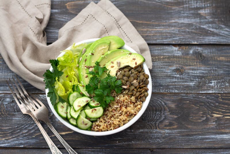 Bacia verde da Buda com lentilhas, quinoa, abacate, pepino, alface fresca, ervas e sementes imagem de stock Bacia verde da Buda com lentilhas, quinoa, abacate, pepino, alface fresca, ervas e sementes imagem de stock
