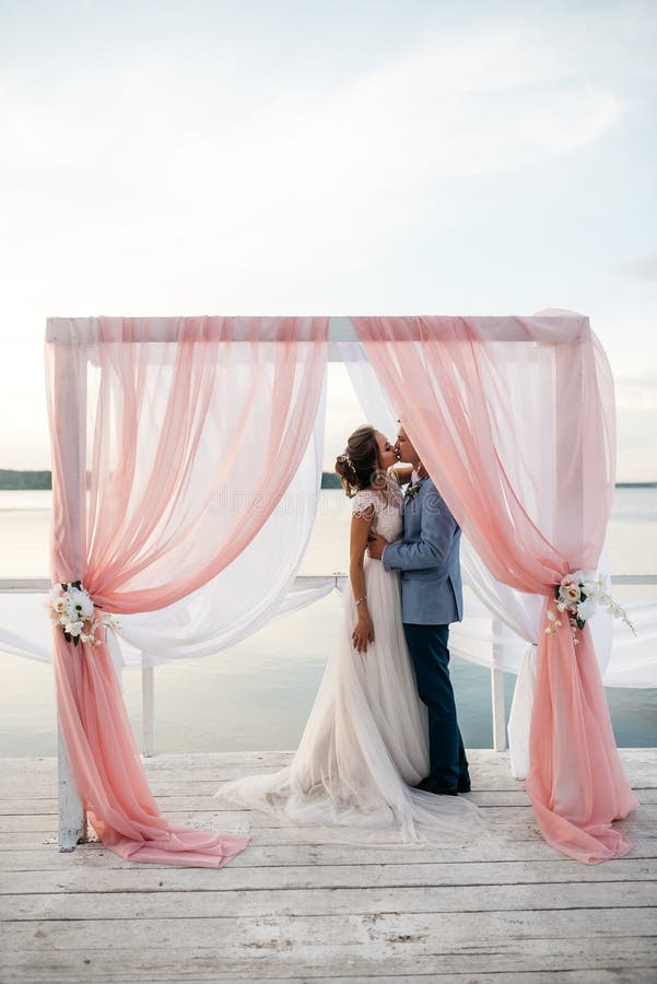 Bacio della sposa e dello sposo all'aperto fotografia stock Bacio della sposa e dello sposo all'aperto fotografia stock