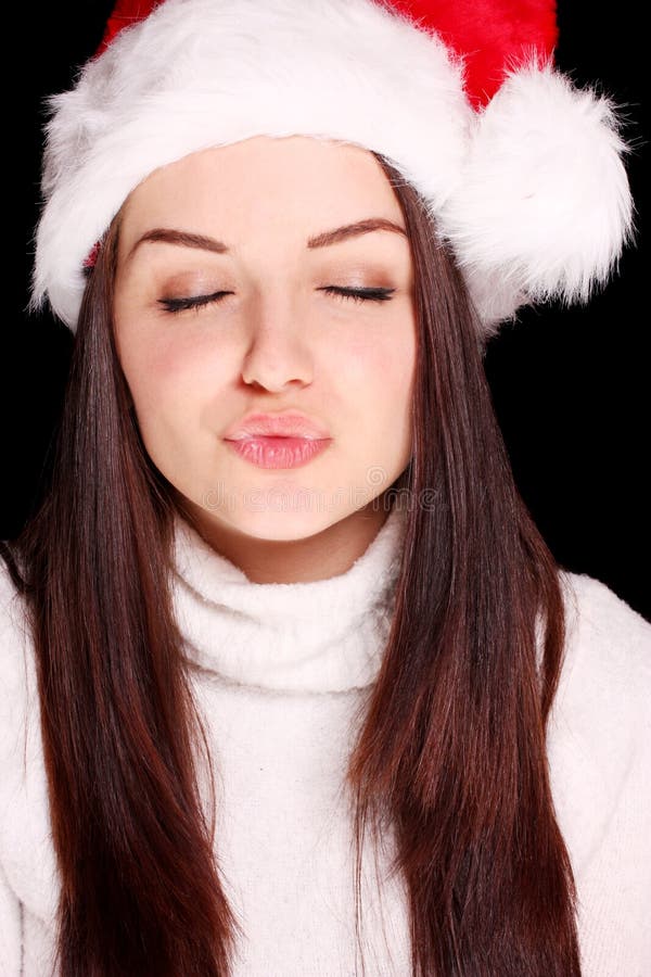Bacio di salto della ragazza in cappello di natale immagine stock libera da diritti Bacio di salto della ragazza in cappello di natale immagine stock libera da diritti