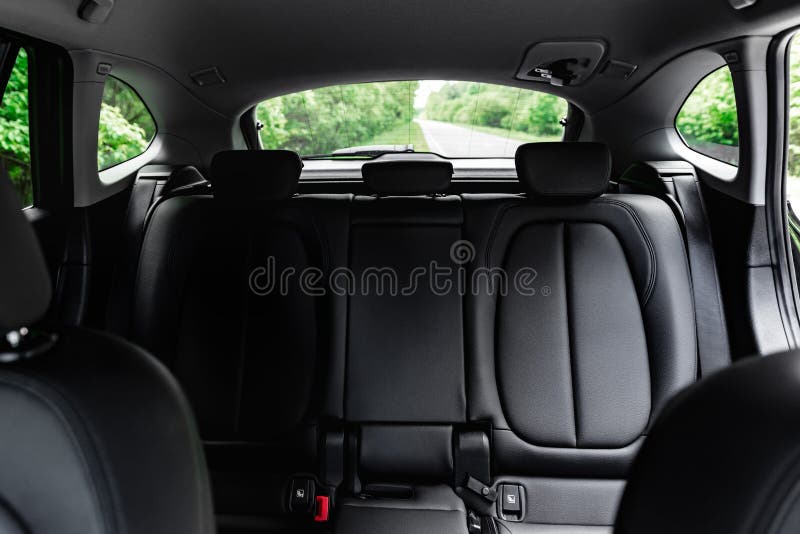 Back black leather passenger seats in modern car.