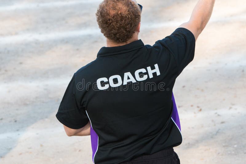 Back of a Coach`s Black Color Shirt with the Word Coach Written