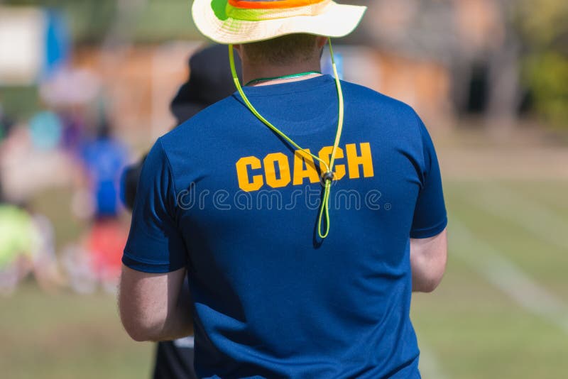 Back of a Coach`s Blue Color Shirt with the Word Coach in Yellow Stock ...