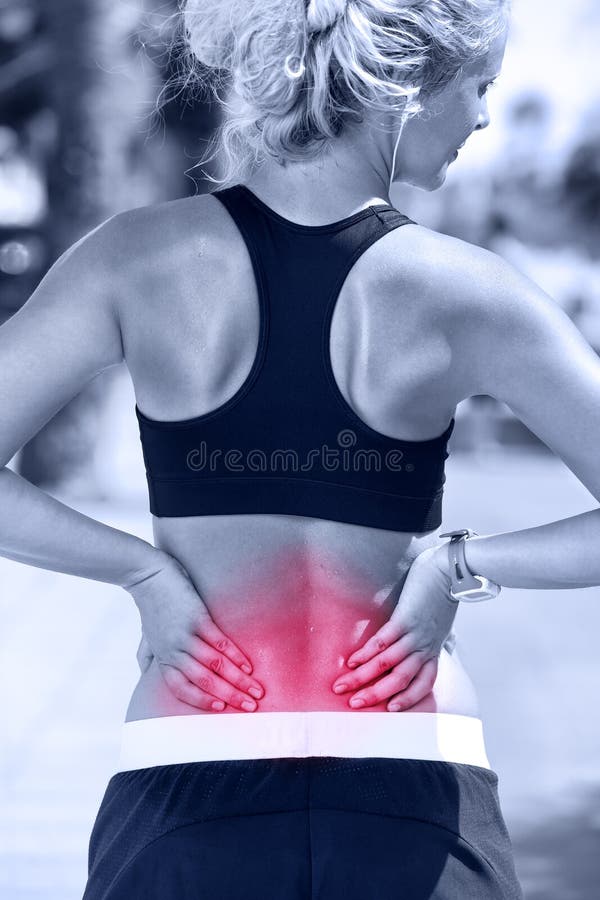 Back pain. Athletic running woman with injury in sportswear rubbing touching lower back muscles outside after exercising and training. Back pain. Athletic running woman with injury in sportswear rubbing touching lower back muscles outside after exercising and training.