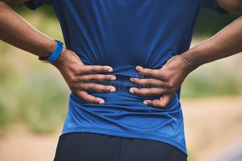 Back pain, fitness and hands of man in park after workout, exercise and training or running outdoors. Medical emergency. Health and closeup of male person with
