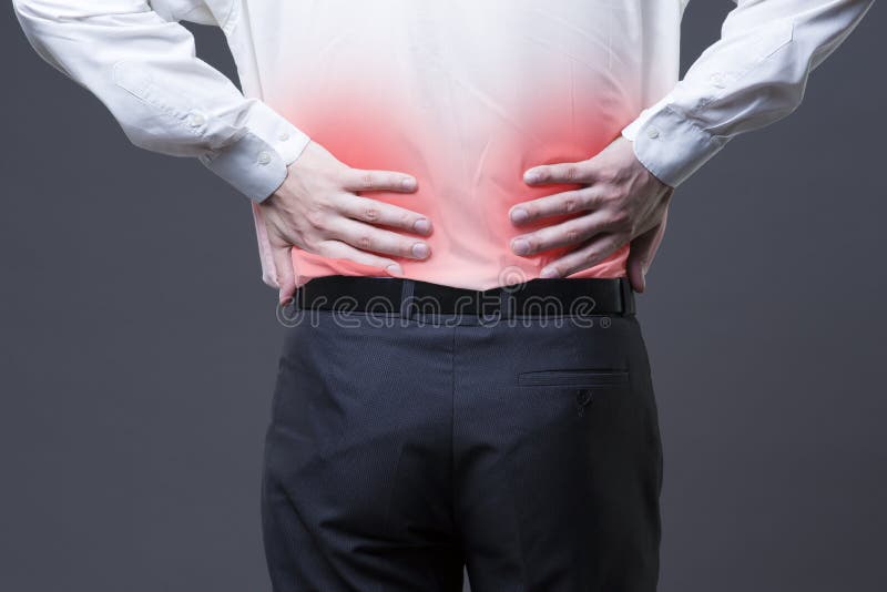 Back pain, kidney inflammation, ache in man`s body close-up on gray background with red dot