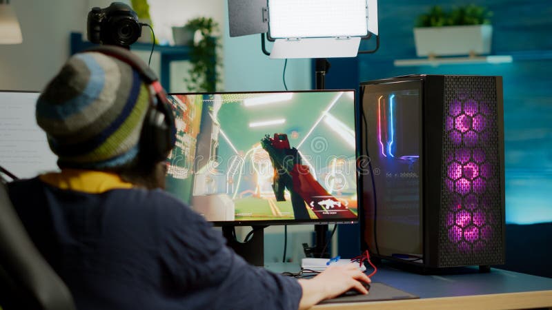 Back shot of pro gamer playing online shooter game on computer using  wireless controller. Competitive player man winning videogame tournament  use professional equipment at home gamming studio Stock Photo - Alamy