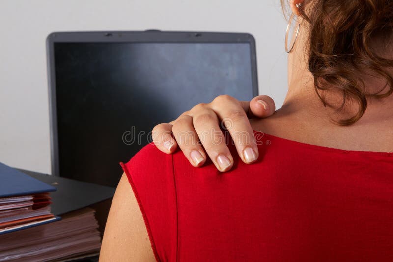 Young woman sitting at her laptop with a lot of work in front of her. She has a pain in her neck / back. Young woman sitting at her laptop with a lot of work in front of her. She has a pain in her neck / back.