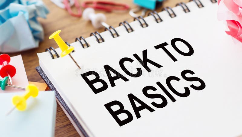 BACK TO BASIC - text on a notepad with wrinkled paper and paper needles on wooden background stock photo