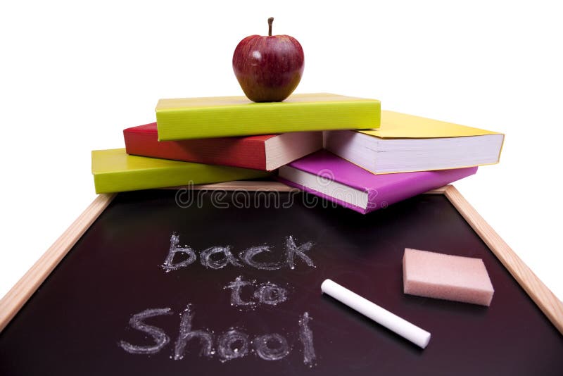 Back to school letters written on a blackboard with colorful books (selective focus)