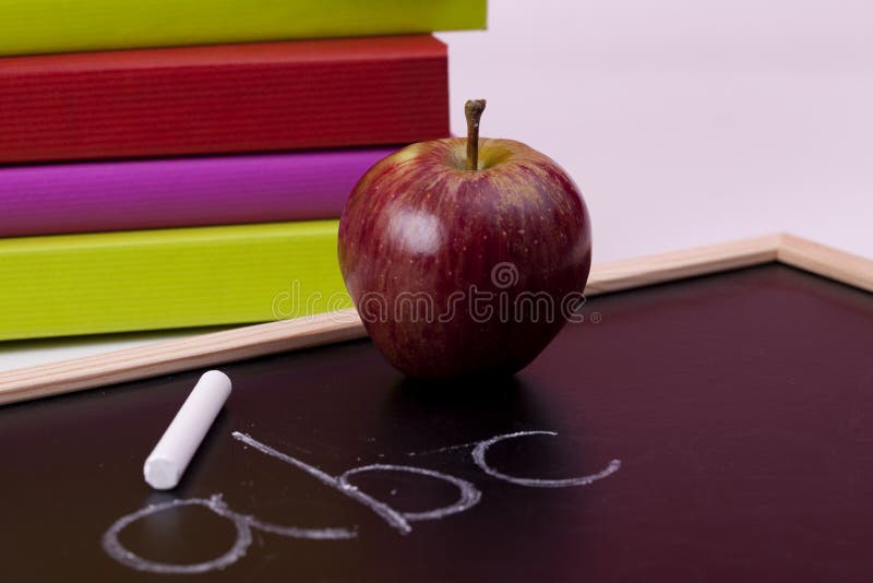 Back to school letters written on a blackboard with colorful books (selective focus)