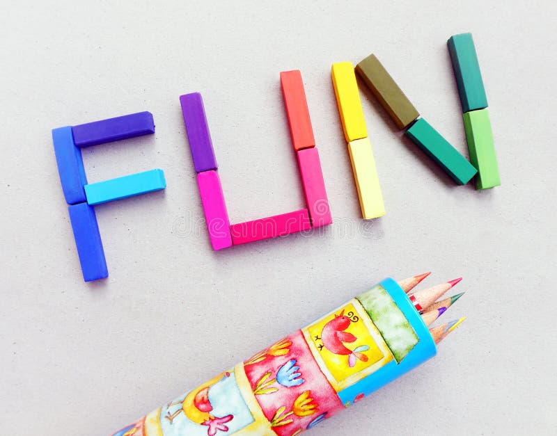 Fun in color pastels - a still life image with the letters of the word FUN spelled out in bright and colorful artist pastels, taken with a background of textured cardboard in light grey. Also with a box of coloring pencils. Concept picture for children having fun in the preschool classroom with art etc. Horizontal colour image. Word art letters stock images, royalty-free photos and pictures