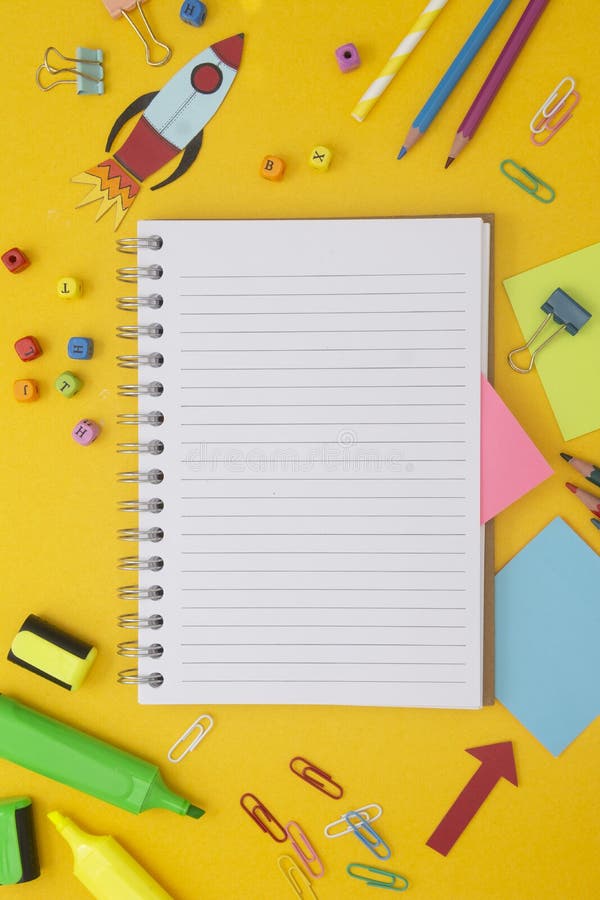 Back to school concept. Colorful rocket, open notebook, school supplies. Yellow background. Flat lay, top view. Copy space stock photography