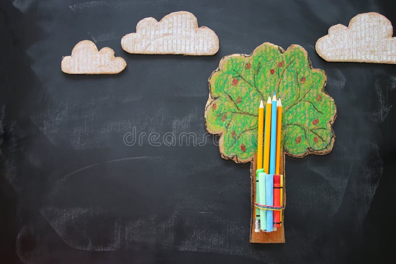 Back to school concept. Top view image tree of knowledge and pencils over classroom blackboard background. stock photos