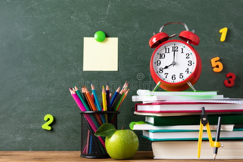 Back to school and education concept with alarm clock, green apple and stationery supplies against blackboard with numbers stock photography Back to school and education concept with alarm clock, green apple and stationery supplies against blackboard with numbers stock photography