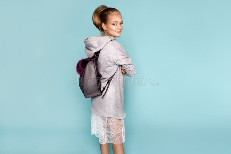 Back to school and happy time! Cute industrious child is breaking through color paper wall. Kid with backpack. Girl ready to study stock photography Back to school and happy time! Cute industrious child is breaking through color paper wall. Kid with backpack. Girl ready to study stock photography