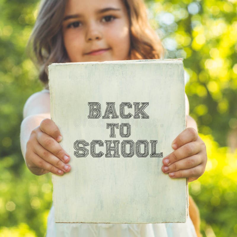 Back to school and happy time! Cute industrious child is standing with a book and a briefcase stock photography Back to school and happy time! Cute industrious child is standing with a book and a briefcase stock photography
