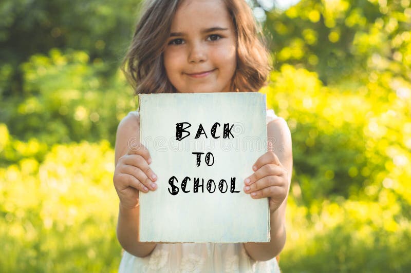 Back to school and happy time! Cute industrious child is standing with a book and a briefcase stock photography Back to school and happy time! Cute industrious child is standing with a book and a briefcase stock photography