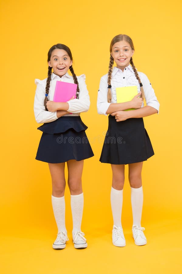 Back to school. Little girls with workbooks for writing. Studying in small groups. Children with school diaries for notes. Cute schoolgirls holding lesson books. School children learn reading books.