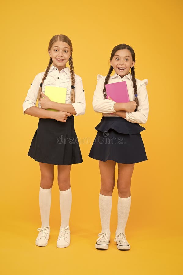 Back to school. Little girls with workbooks for writing. Studying in small groups. Children with school diaries for notes. Cute schoolgirls holding lesson books. School children learn reading books.