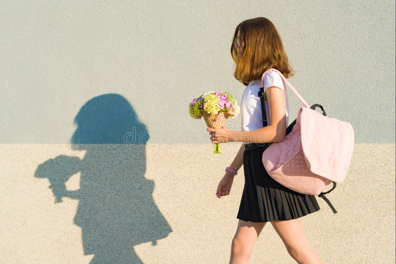 Back to school. Outdoor portrait of happy teenage girl with backpack, flowers, copy space royalty free stock photography Back to school. Outdoor portrait of happy teenage girl with backpack, flowers, copy space royalty free stock photography