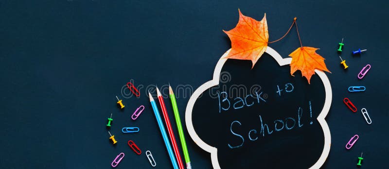 Back to school over chalkboard background. School supplies on dark background. Creative copy space for seasonal projects and basis designs. Close-up