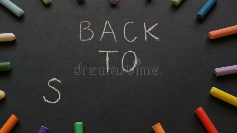 Back to school. Stop motion animation. Black chalkboard with text on it. Colorful chalks. Animated background.