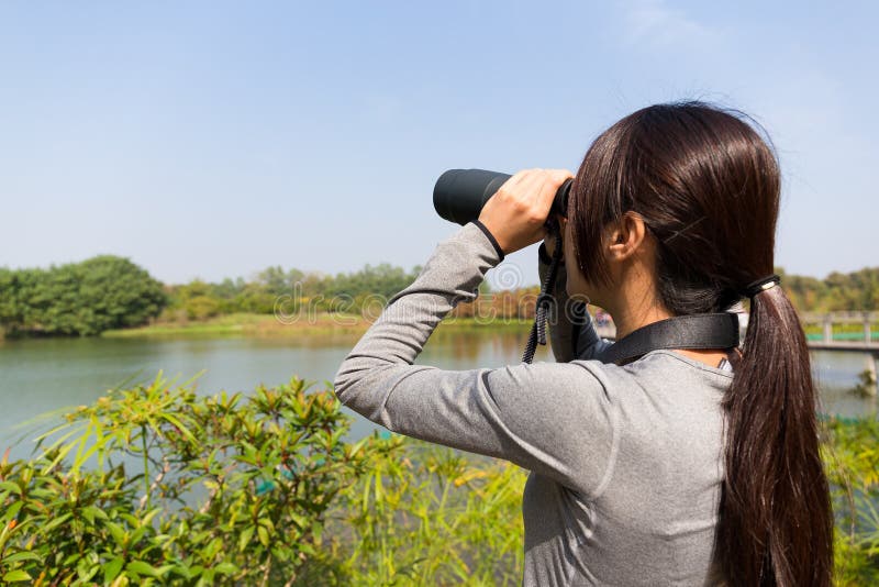 The back view of Asian Young woman using binocular stock photo The back view of Asian Young woman using binocular stock photo