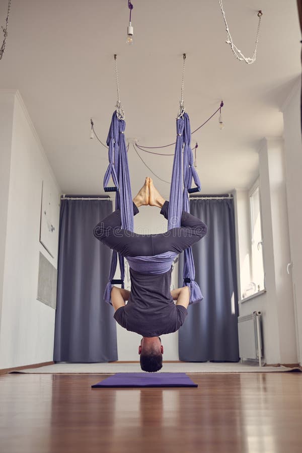 Barefoot Young Man Hanging Upside Down in Yoga Studio Stock Image