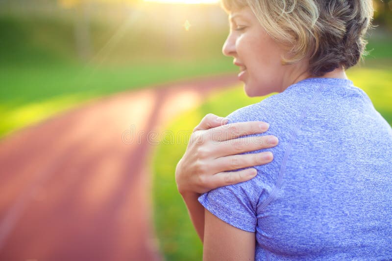 Back view of athletic young woman in sportswear touching her painful neck at the stadium. Sport, health and people concept royalty free stock photo Back view of athletic young woman in sportswear touching her painful neck at the stadium. Sport, health and people concept royalty free stock photo